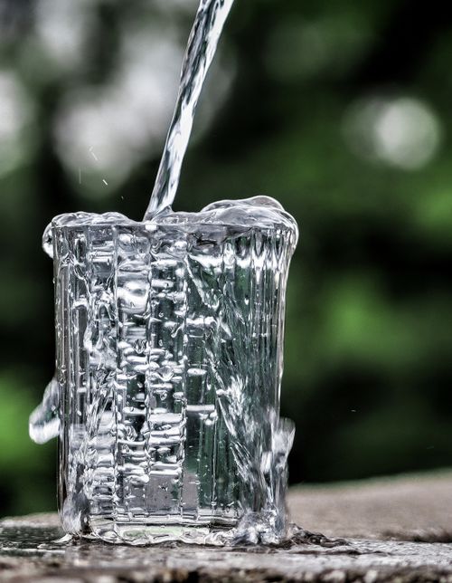 Free Close-up of water being poured into a glass, creating a dynamic splashing effect. Stock Photo