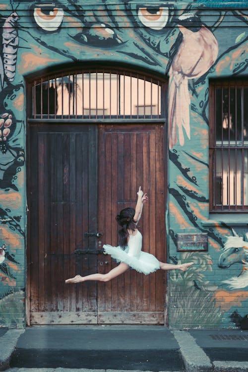 Free Woman Dancing in Front of a Wooden Door Stock Photo