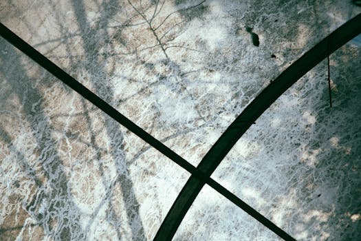 An abstract view of shadows and lines through glass creating a textured surface.