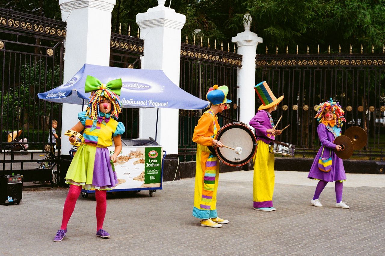 vibrant clowns performing with musical instruments outdoors in a livel