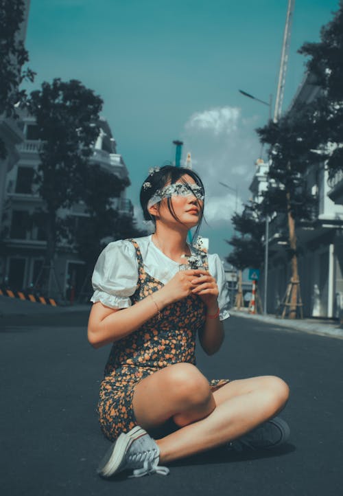 Woman in Dress Sitting on Street