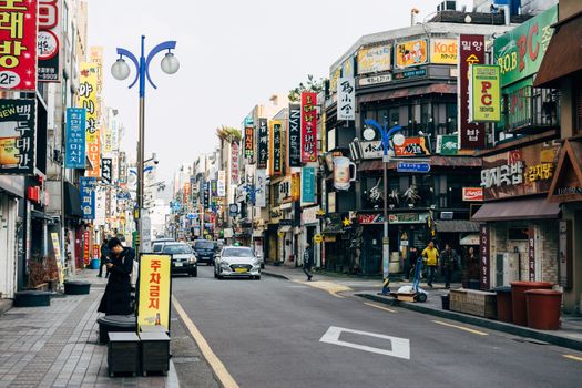 Colorful city street in Busan with bustling activity and diverse signage. Captivating urban scenery.