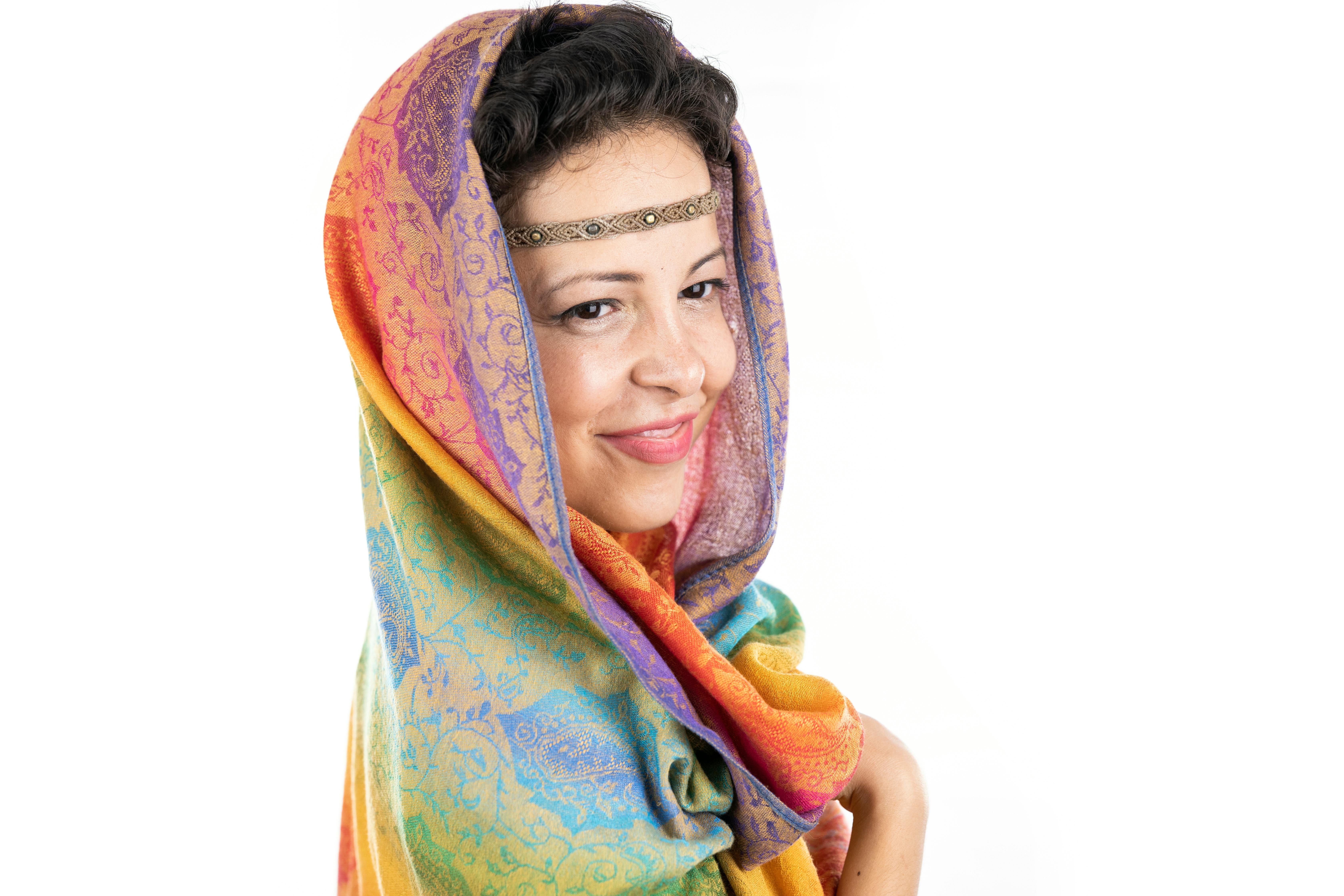 Vibrant portrait of a woman wearing a colorful headscarf, exuding warmth and beauty.