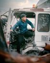 Man in Green Jacket Sitting on Car