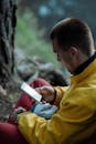 Man in Yellow Jacket Holding his Phone