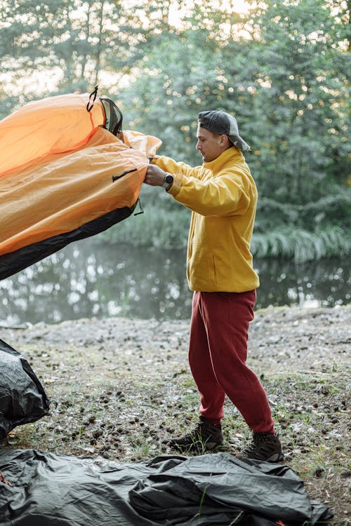 Mann Im Gelben Langarmhemd Und In Der Roten Hose, Die Orange Textil Halten