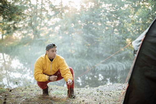 Pria Berjaket Kuning Dan Celana Merah Memegang Joran