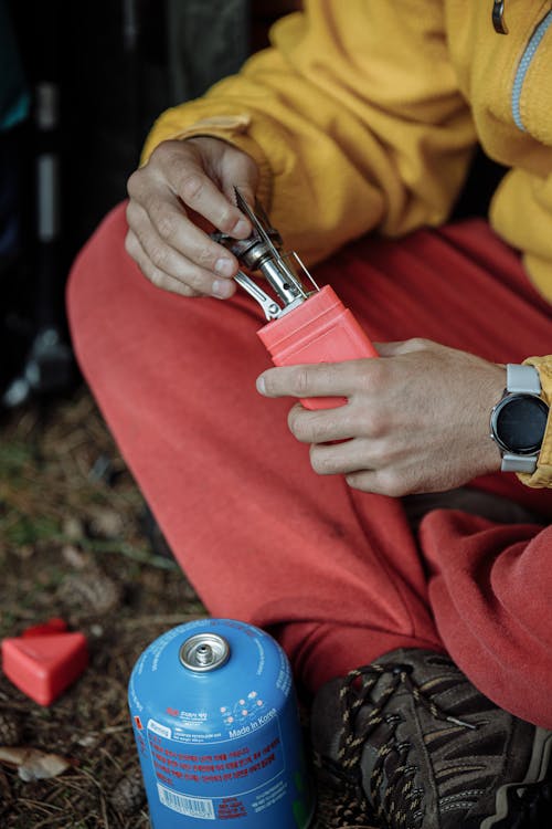 Orang Berkemeja Lengan Panjang Merah Memegang Botol Perak Dan Biru