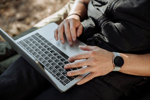 Person in Black Zip Up Jacket Using Laptop