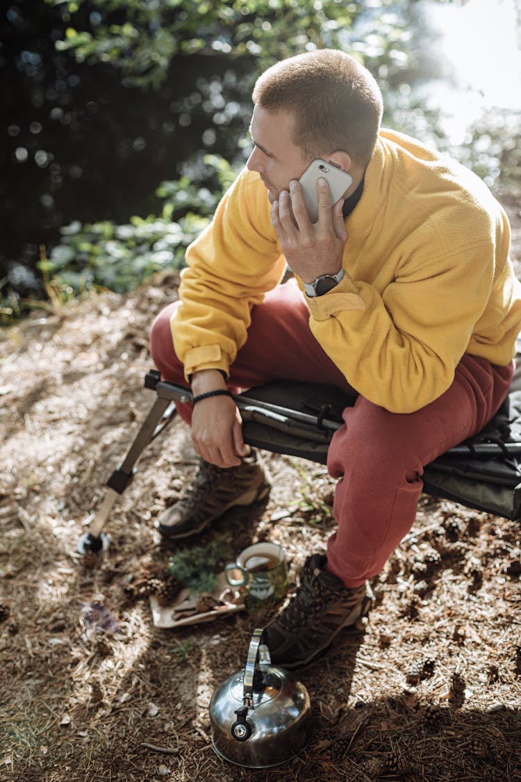 Man In Yellow Sweater Talking On His Phone