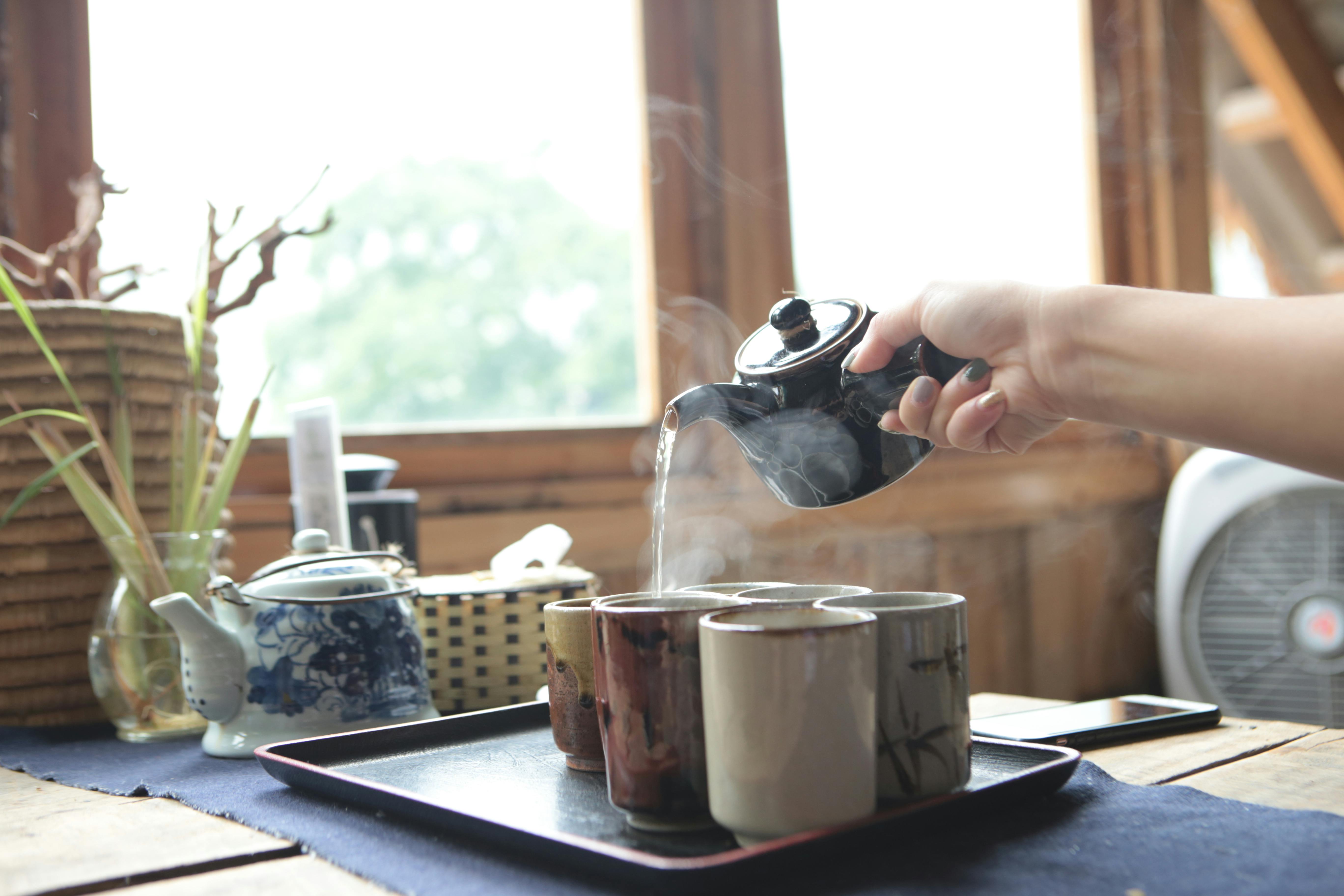 Close-up view of pouring hot tea from thermos into cup Stock Photo
