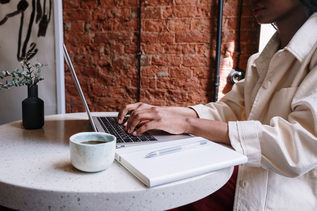 Researching with notebook and laptop over coffee — answers with citations