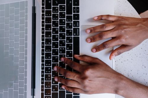 Free Hands typing on a laptop keyboard, showcasing online work and technology. Stock Photo