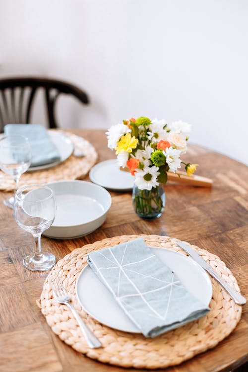 бесплатная Белая керамическая тарелка на коричневом деревянном столе Стоковое фото