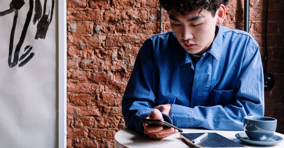 Young hispanic man using WhatsApp on phone to get auto insurance quote in Fort Myers Florida