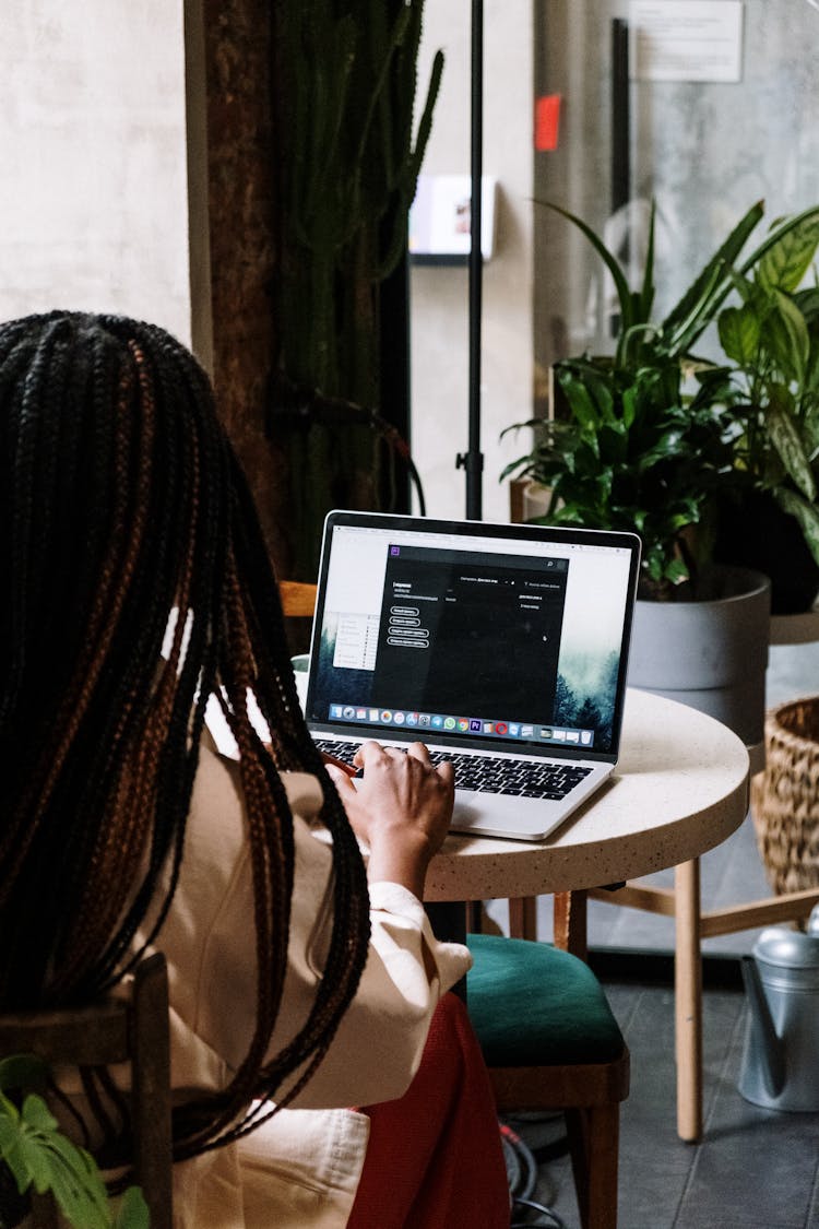 Person Using Macbook Pro On Brown Wooden Table