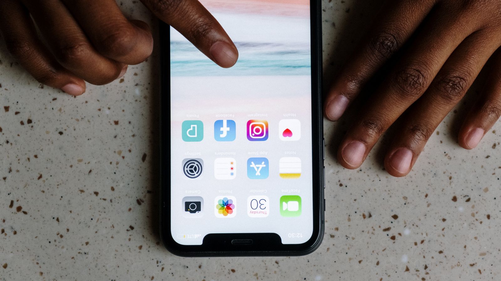 A finger tapping an app icon on a smartphone screen