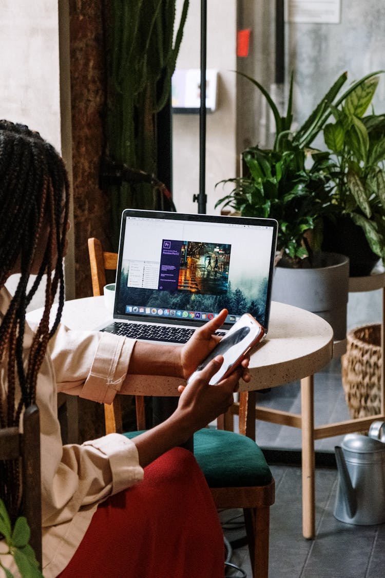 Person Holding Iphone 6 Near Macbook Pro