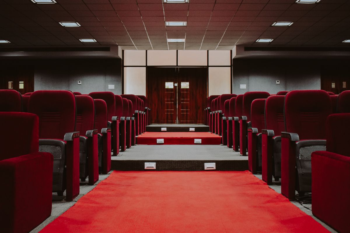 Empty auditorium with rows of red velvet seats