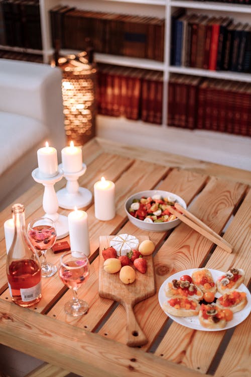 A Variety of Foods on a Wooden Table Near the Lighted Candles