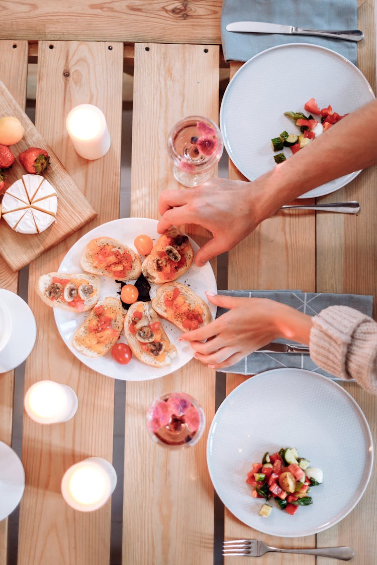 A Person Getting Bruschetta On The Plate