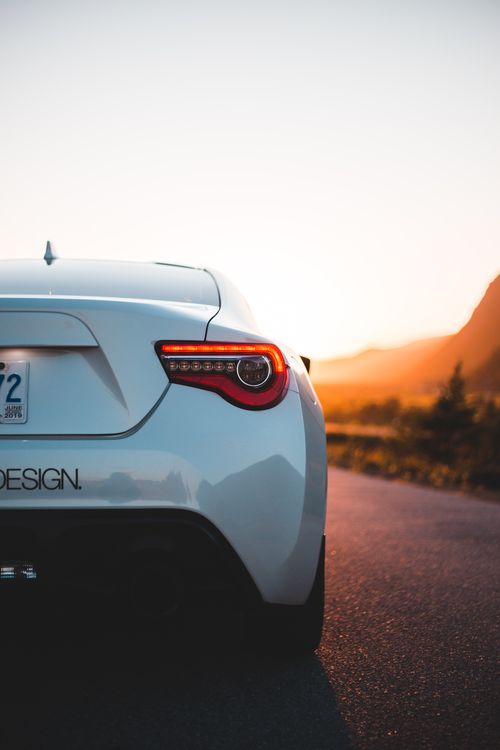 Free Back detail of white shiny car on smooth asphalt route in back lit of sunset light Stock Photo
