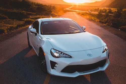 High angle of coupe grand tourer car on asphalt route in sundown light