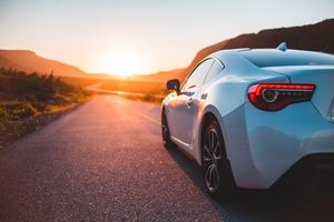 Silver coupe parked on an open desert road at sunset — photo by Erik Mclean on Pexels