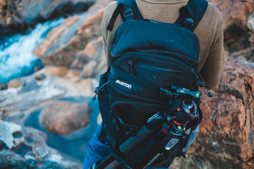 Crop traveler standing near mountain stream