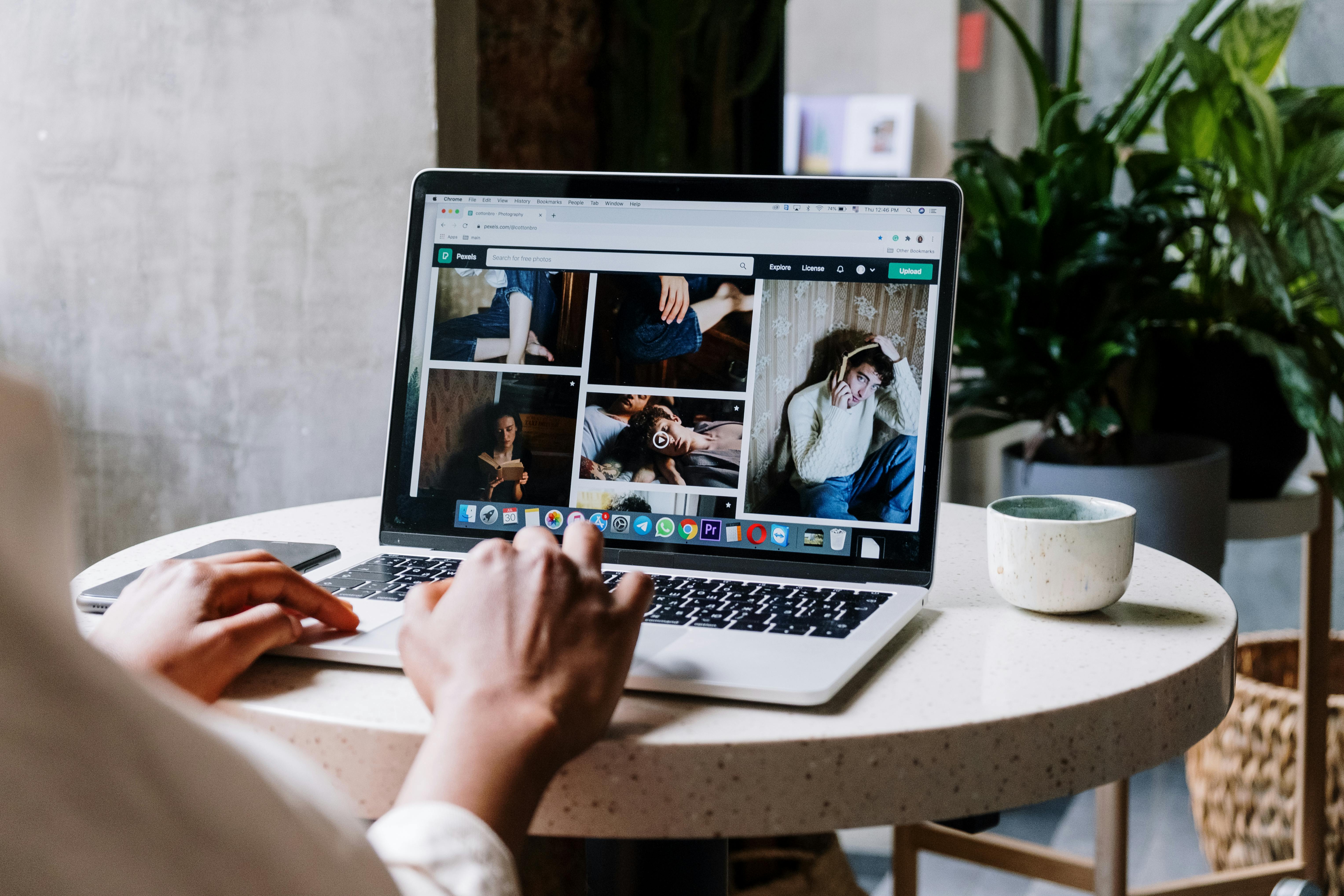 person using macbook air on white table