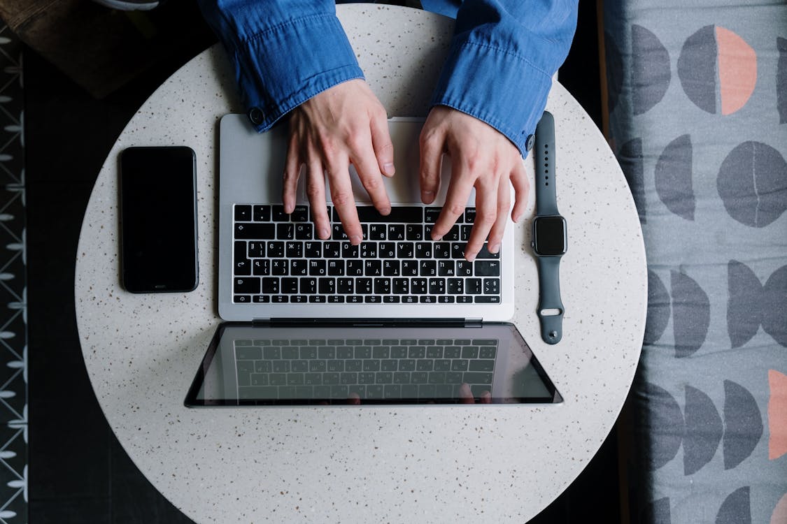 Free Person in Blue Denim Jeans Using Macbook Pro Stock Photo