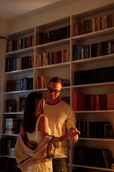 一对浪漫的夫妇在灯光温暖的图书馆里跳舞，增进感情