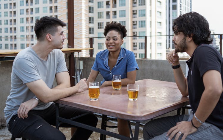 A Group Of Friends Having Conversation While Looking At Each Other