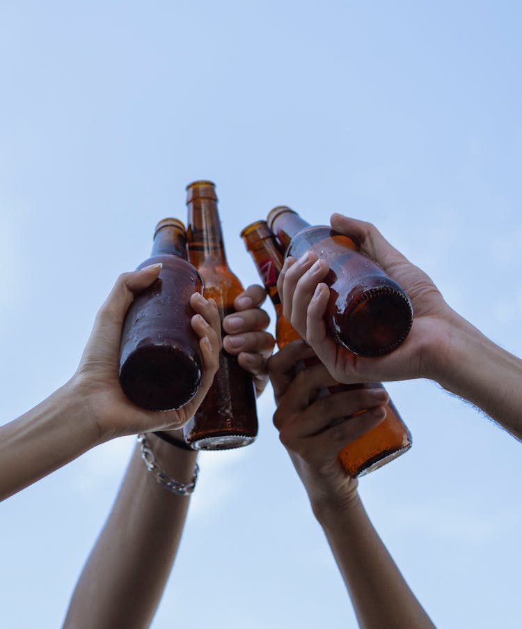 People Clinking Beer Bottles