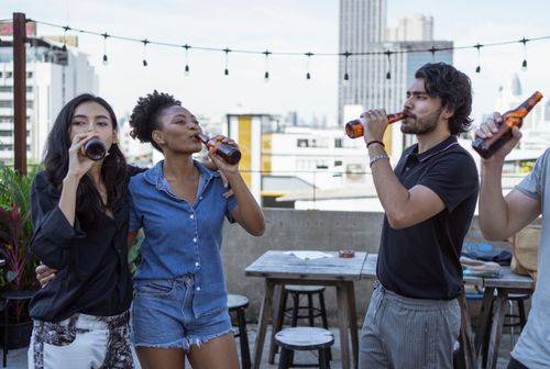 Free A group of friends enjoying drinks on an urban rooftop, having fun together. Stock Photo