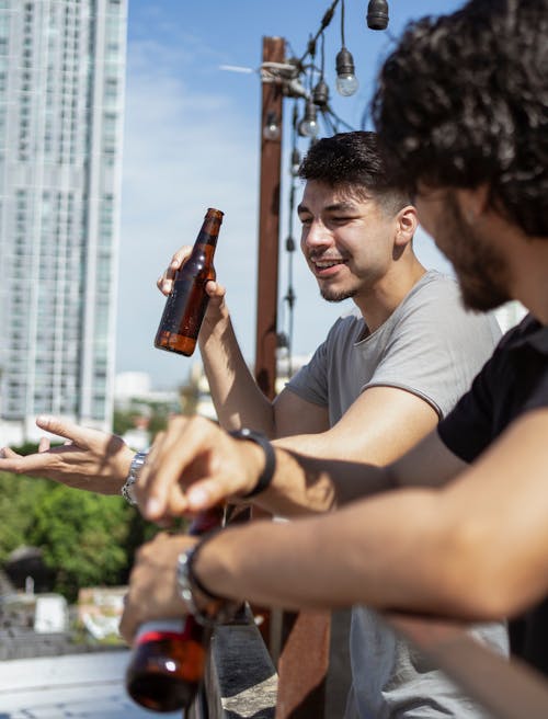 Man Holding a Brown Bottle