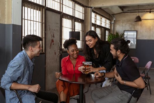 A lively group of adults socializing and enjoying drinks in a comfortable indoor setting.