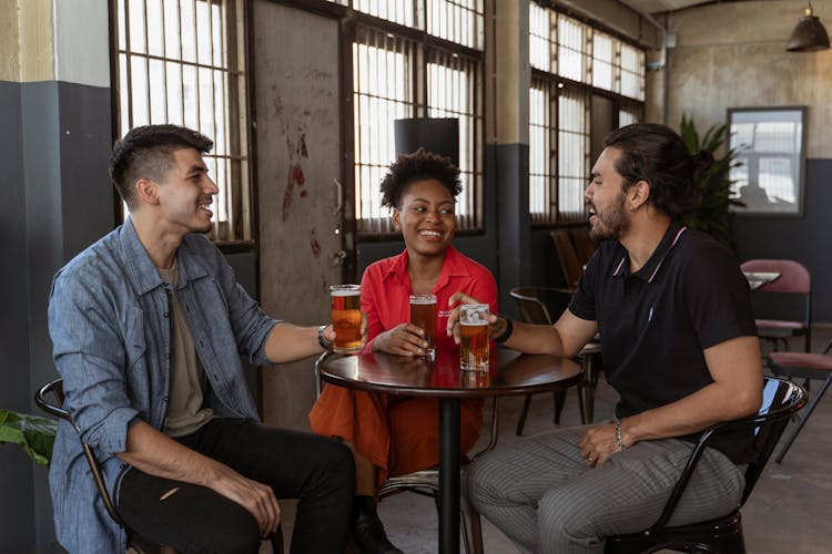 Friends Sitting In A Pub And Drinking Beer 