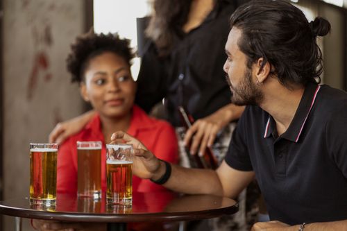 Free Diverse group of friends enjoying drinks and conversation indoors. Stock Photo