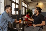 两名男子在咖啡馆里边喝啤酒边友好地交谈