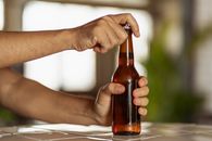 Person Holding Brown Glass Bottle