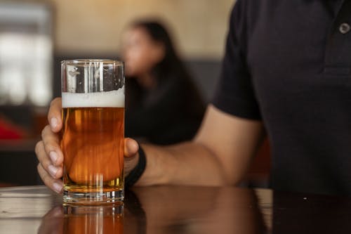 Close-up of a Mans Hand Holding a Glass of Beer
