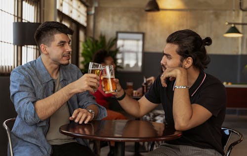 Free Men Toasting a Drinks while Having Conversation Stock Photo