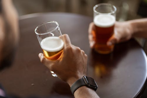 A Person Holding a Drinking Glass with Beer