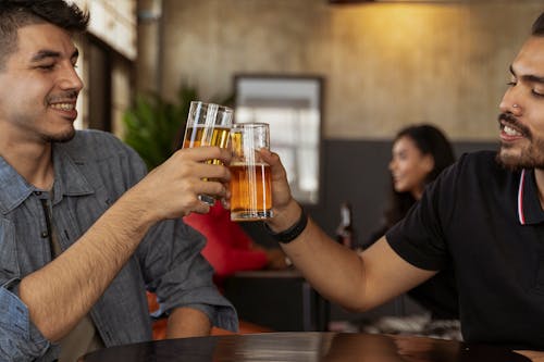 Free Men Toasting Drinks while Having Conversation Stock Photo