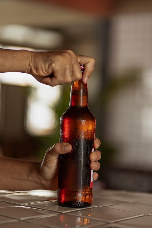 A Person Holding a Brown Glass Bottle