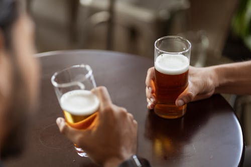 Two Men Holding Drinking Glasses With Beer