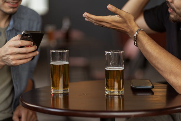 Two Drinking Glasses Of Beer On The Table