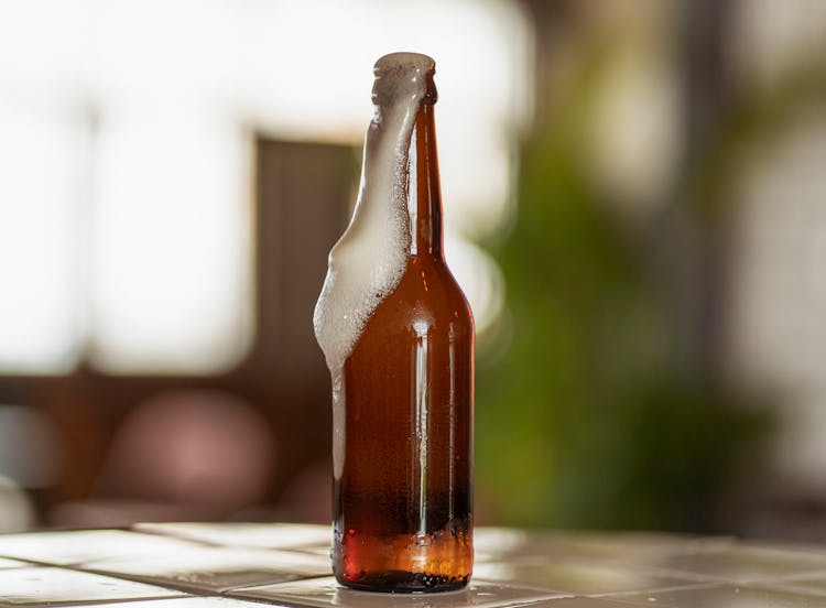 Beer Foam Flowing Out Of The Bottle