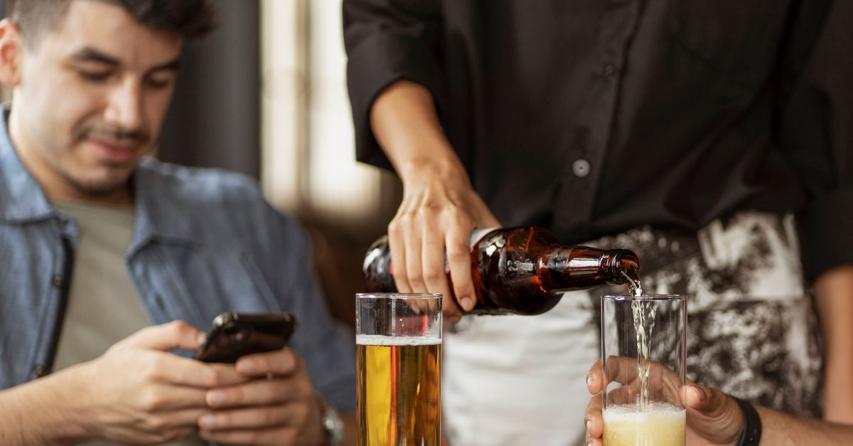 friends at a restaurant checking a phone budget app together